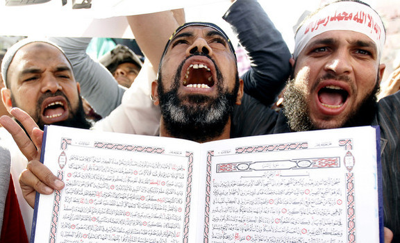 An Islamist Egyptian protester shouts holding a Koran during a protest of hundreds of Salafists gather for the enforcement of Islamic sharia law at Tahrir Square in Cairo